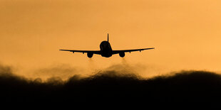 Ein Flugzeug startet vor gelbem Himmel