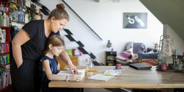 Eine Mutter hilft ihrer Tochter bei den Hausaufgaben