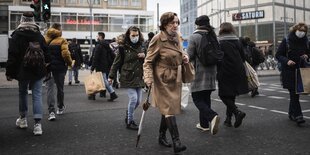 Fußgänger überqueren die Ampel am Alexanderplatz