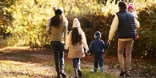 Vater Mutter und drei Kinder im Herbstwald