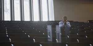 Ein Stuudent sitzt alleine in einem Hörsaal der Universität in Freiburg
