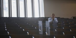 Ein Stuudent sitzt alleine in einem Hörsaal der Universität in Freiburg