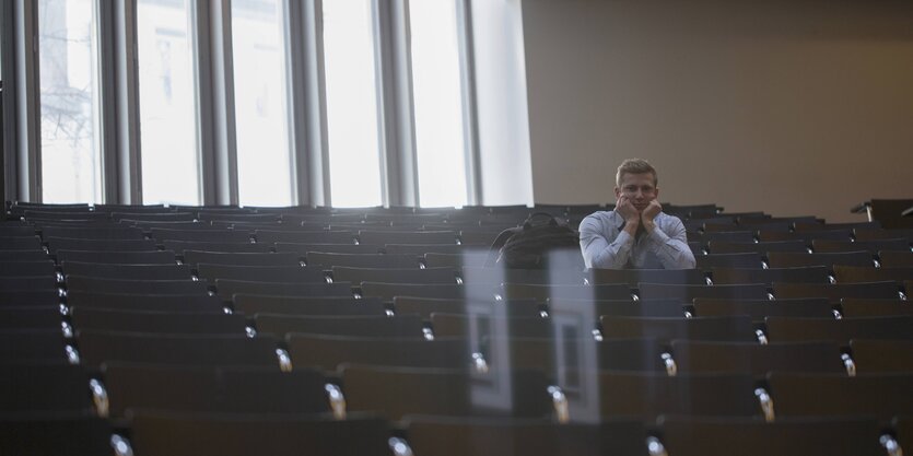 Ein Stuudent sitzt alleine in einem Hörsaal der Universität in Freiburg