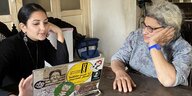 Mona Seif und ihre Mutter Leila sitzen an einem Tisch mit einem Rechner