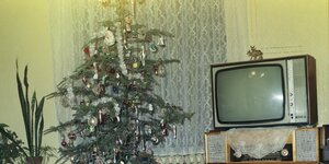 Ein mit Lametta behängter Weihnachtsbaum un ein alter Röhrenfernseher auf einem verblichenem Foto von 1980