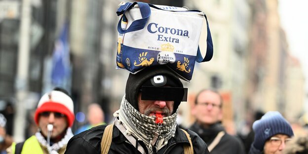 Teilnehmer einer Demonstration mit einer Tasche "Corona Extra" auf dem Kopf