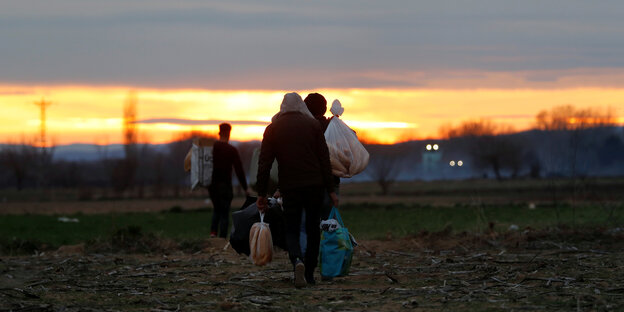 Migranten laufen über ein Feld nahe der Grenze zwischen der Türkei und Griechenland bei Edirne