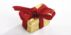 Goldbarren mit rotem Geschenkbad umwickelt