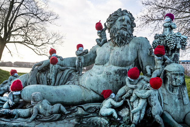 Dänemark, Kopenhagen: Die kleinen Kinder der Bronzefigurengruppe des Nilen sind mit roten Weihnachtsmützen dekoriert und mit Mund-Nasen-Bedeckungen versehen