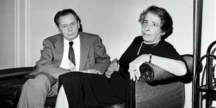 Blücher und Arendt auf einem Sofa in die Kamer blickend