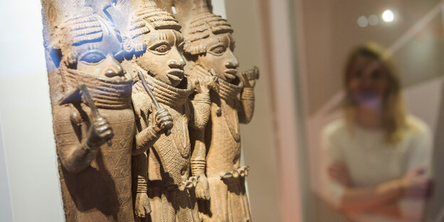 Raubkunst-Bronzen – in Relief mit drei stilisierten Menschenfiguren – aus dem Land Benin in Westafrika sind im Hamburger Museum für Kunst und Gewerbe (MKG) in einer Vitrine ausgestellt
