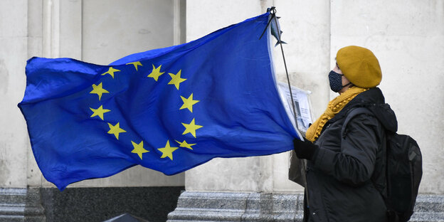 Eine Brexit-Gegnerin hält eine wehende EU-Fahne