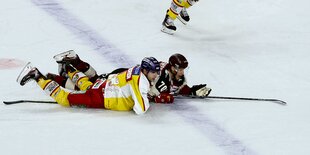 Die beiden Eishockeyspieler Kammerer und Zalewski liegen beim Spiel bäuchlings auf dem Eis