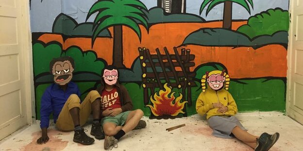 Drei Menschen mit comichaften Masken vorm Gesicht – m Hintergrund Palmen
