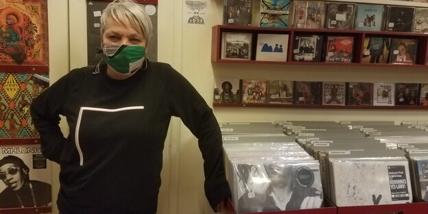 Marga Glanz mit Mundnasenschutzmaske vor ihren Plattenregalen