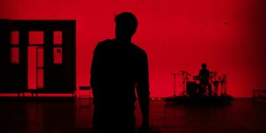 Die Bühne ist in rotes Licht getaucht, als Silhouette sieht man Benjamin Lillie und Matze Prölloch am Schlagzeug