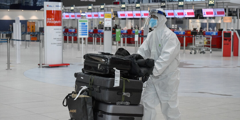 Ein Flugpassagier am Flughafen Prag in Schutzanzug