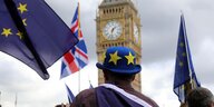 Ein Mann mit blauem Hut und EU Sternen steht vor dem Big Ben Clock Tower