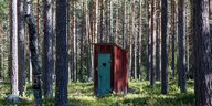 Toilettenhäuschen mit Herztür in einem Wald