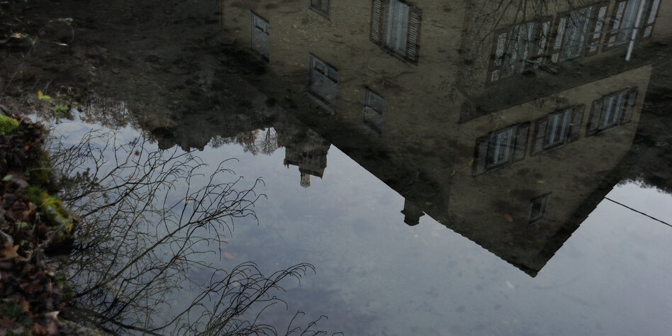Ein Haus spiegelt sich in einem Teich