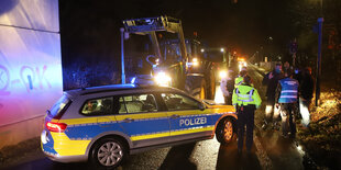 Bauern stellen mit Traktoren die Zufahrten zu einem Aldi-Lager in Weyhe zu. Polizisten halten Rettungswege frei.