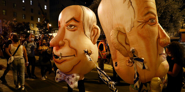DemonstrantInnen mit aufblasbaren Masken von Netanjahu und seinem Koalitionspartner Benny Gantz im August