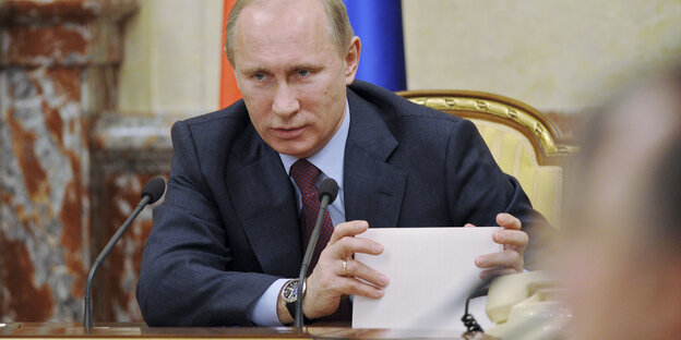 Vladimir Putin während während eines Regierungstreffens mit einem Stapel Papier
