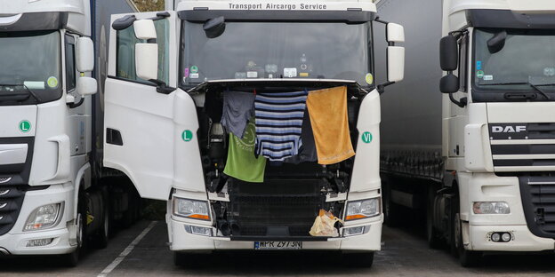Kleidung und Handtücher hängen zum trocknen unter der Motorhaube eines Lkw