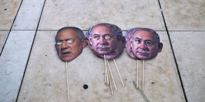 An einem Holzstab angeklebte Papier-Masken, die die Gesichter des israelischen Premierministers Netanjahu und des israelischen Verteidigungsministers Gantz darstellen, liegen auf dem Boden