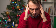 Ein frustririerter Mann vorm Weihnachtsbaum