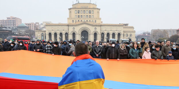 Menschen bei einer Demonstration mit einer armenischen Fahne.