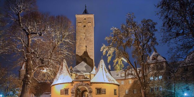 Mittelalterliches Tor mit Turm, im Dunkeln und verschneit