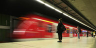 Reisende mit Mundschutzmaske, warten auf einfahrende S-Bahn in Stuttgart