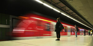 Reisende mit Mundschutzmaske, warten auf einfahrende S-Bahn in Stuttgart