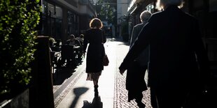 Spaziergängerin und Schatten auf einem Strassenpflaster