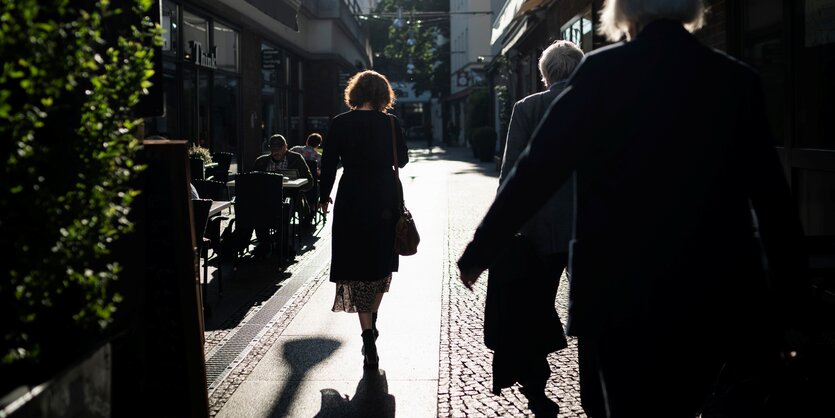 Spaziergängerin und Schatten auf einem Strassenpflaster