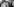 Schwarzweißaufnahme von Pierre Cardin in anzug und mit Fliege in einer Garderobe stehend, Kleider hängen von der Stange