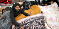 Junge Migranten suchen unter Decken Schutz vor der Kälteaben unter