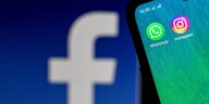 facebook Logo auf einem größeren Bildschirm - Whatsapp und instagram Logos auf einem Sartphone Display im Vordergrund