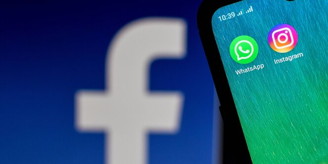 facebook Logo auf einem größeren Bildschirm - Whatsapp und instagram Logos auf einem Sartphone Display im Vordergrund