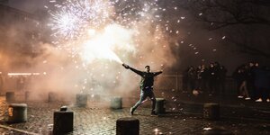Ein Mann versprüht Pyrotechnik auf der Admiralsbrücke in Berlin