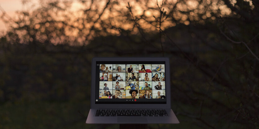 Ein aufgeklappter Laptop auf dessen Bildschirm ein Video-Chat mit 5 Personen zu sehen ist