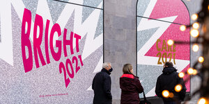 Passanten vor Schaufensterbeklebung am KaDeWe in Berlin mit dem Schriftzug "Bright 2021"