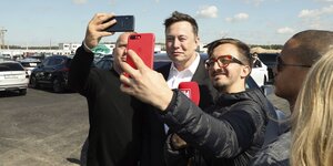 Tesla-Gründer Elon Musk auf der Baustelle umringt von Selfifotografen