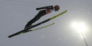 Ein Skispringer im gegenlicht eines Flutlichtstrahlers