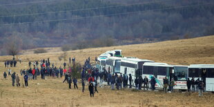 Migranten warten voor Bussen in der Nähe des Camps in Lipa