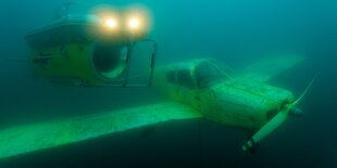 U-Boot und Propellerflugzeug unter Wasser