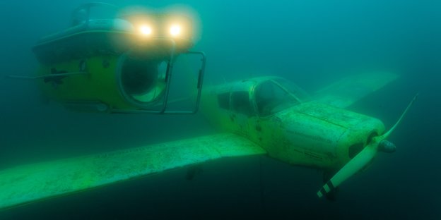 U-Boot und Propellerflugzeug unter Wasser