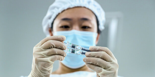 Ein Mitarbeiter prüft die Verpackungsqualität von inaktivierten Corona-Impfstoffprodukten