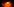 Eine ausgehöhlte Mandarine, in der eine Flamme brennt, im Hintergrund Mandarinenstücke